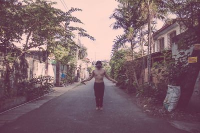 Rear view of woman walking on road in city