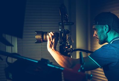 Side view of man adjusting camera