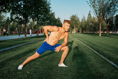 Full length of man exercising on field