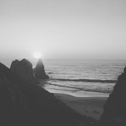 Low section of silhouette man on beach against clear sky