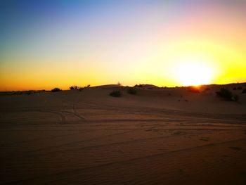 Scenic view of desert against clear sky during sunset