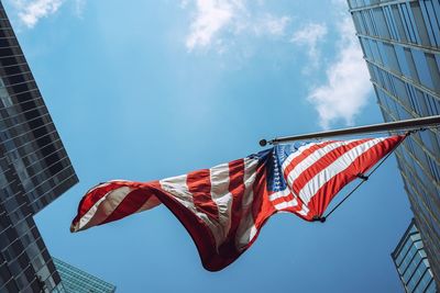 Low angle view of flags against buildings against sky