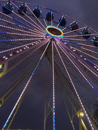 Low angle view of illuminated ferris wheel against sky at night