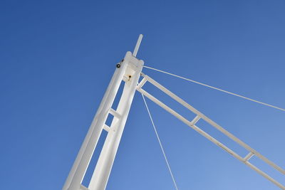 Low angle view of wind turbine against clear blue sky