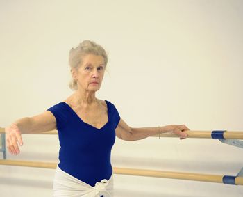 Mid adult woman standing against wall