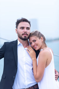 Portrait of young woman with man embracing outdoors