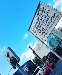 Low angle view of information sign against blue sky