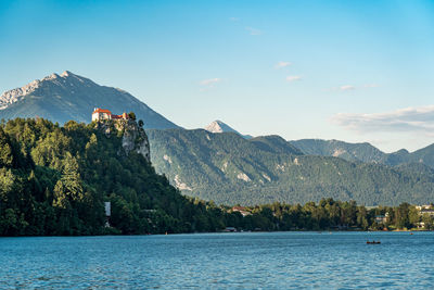 Scenic view of lake by mountains against sky