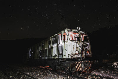 Abandoned train against sky at night