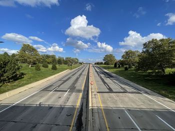 Road amidst trees against sky