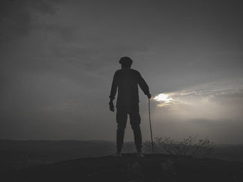 Rear view of silhouette man standing against sky