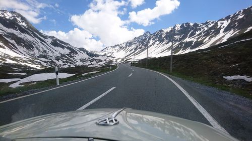 Road amidst snowcapped mountains against sky