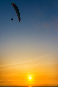 Low angle view of parachute flying against clear sky