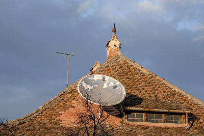 Romanian ceramic shingle roof with brick chimney and old television antenna