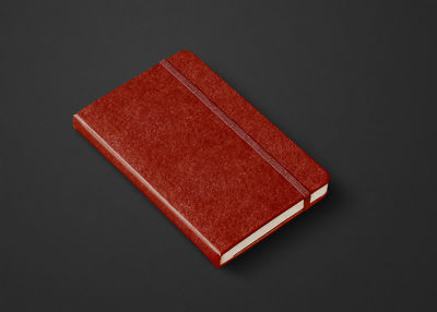 High angle view of red book on table against black background