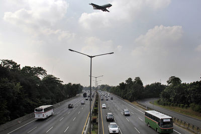 Airplane flying over vehicles on roads