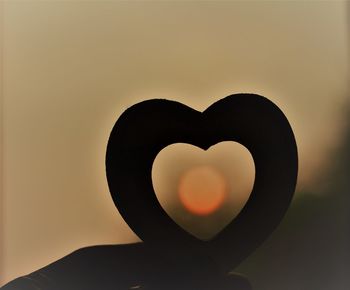 Close-up of silhouette heart shape against sky during sunset