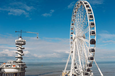 Ferris wheel at beach against sky