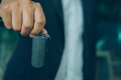 Midsection of salesman showing car key