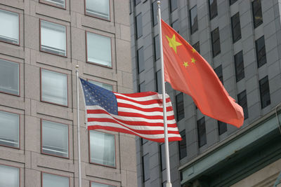 Low angle view of national flags against building in city