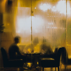Blurred motion of people sitting in glass window