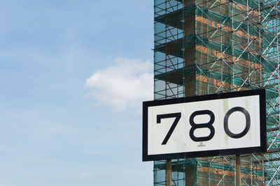 Low angle view of number on billboard against building