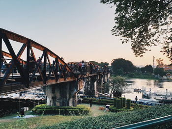 Bridge over river against sky during sunset