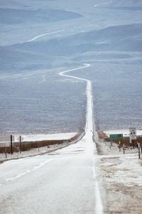 Snow covered road amidst landscape