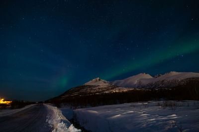 Scenic view of snowcapped mountains against sky at night