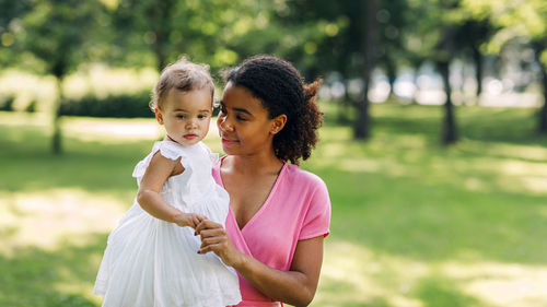 Mother and daughter standing outdoors