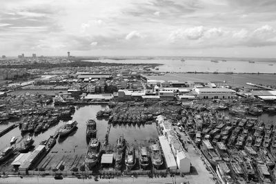 High angle view of cityscape by sea against sky