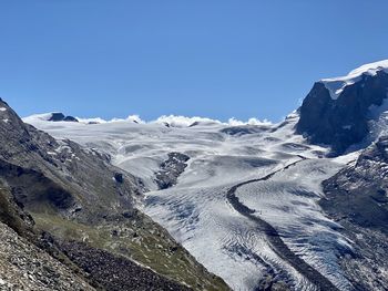 Scenic view of snowcapped mountains against clear blue sky