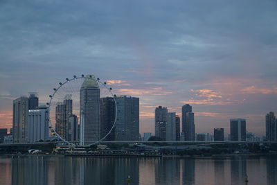 Modern buildings in city against sky during sunset