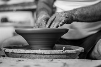 Cropped hands of potter making pot in pottery workshop