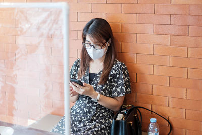 Woman using smart phone sitting at cafe