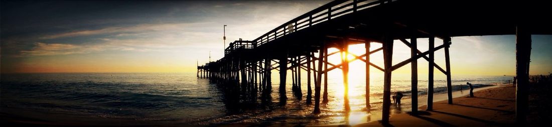 Pier on sea at sunset
