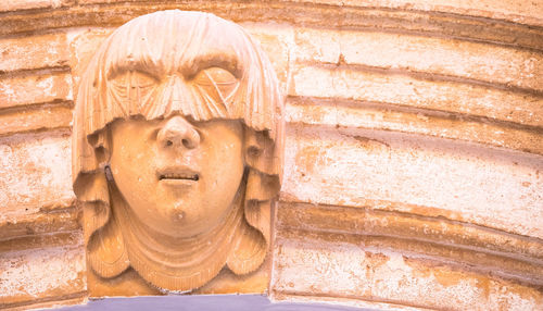 Close-up of buddha statue against wall