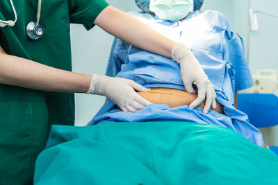 Midsection of doctor examining patient in hospital