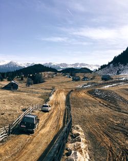 Cars on dirt road against sky