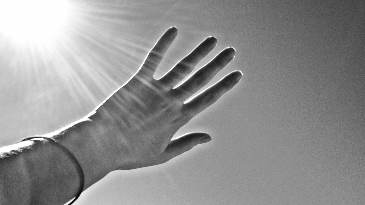 person, part of, human finger, cropped, lifestyles, holding, sunlight, personal perspective, close-up, unrecognizable person, sun, leisure activity, lens flare, sunbeam, showing, day