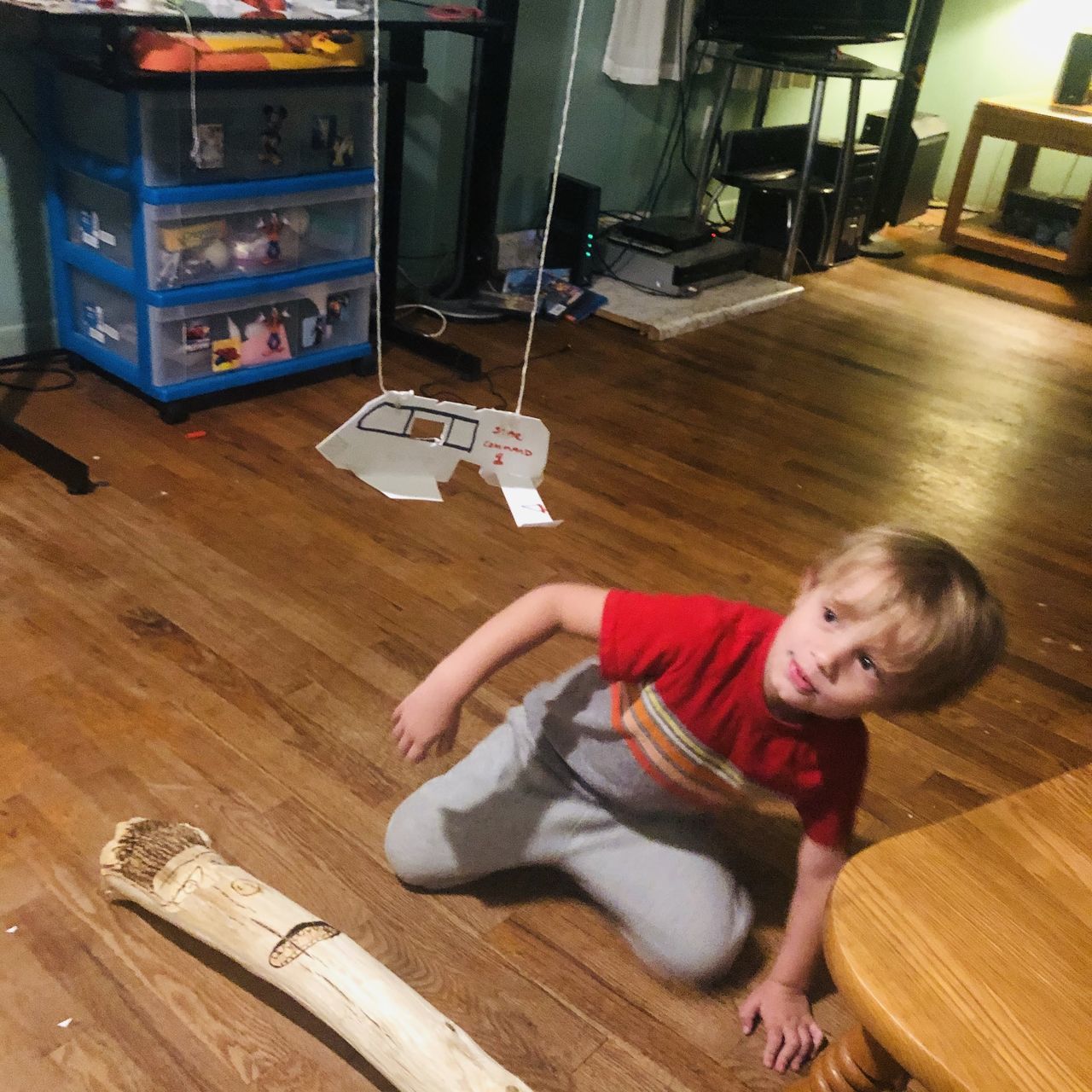 PORTRAIT OF BOY LYING ON HARDWOOD FLOOR