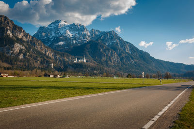 Scenic view of road by mountains against sky