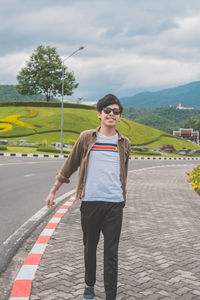 Full length of man standing on road against sky