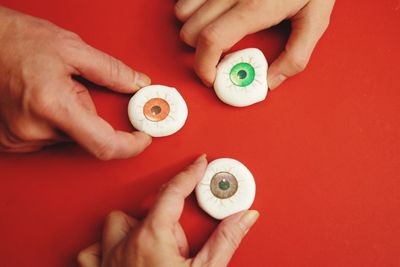 Cropped hand of people holding toy on table