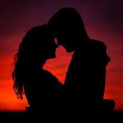 Silhouette couple against sky during sunset