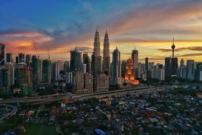 View of cityscape against cloudy sky during sunset