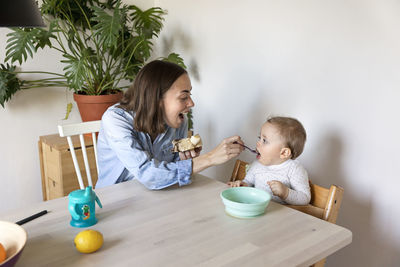 Mother feeding baby at table