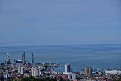 High angle view of city by sea against sky