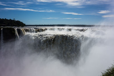 Scenic view of waterfall against sky