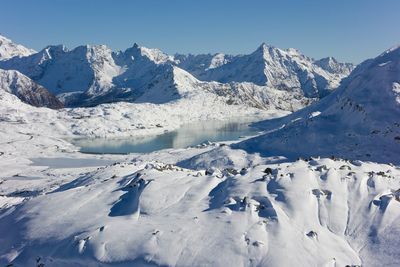 Scenic view of snowcapped mountains against blue sky